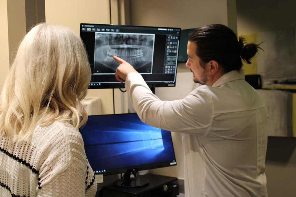 Dr. Andrew Mancin reviewing a panoramic dental x-ray with a patient at OP Implant Dental in Overland Park, KS