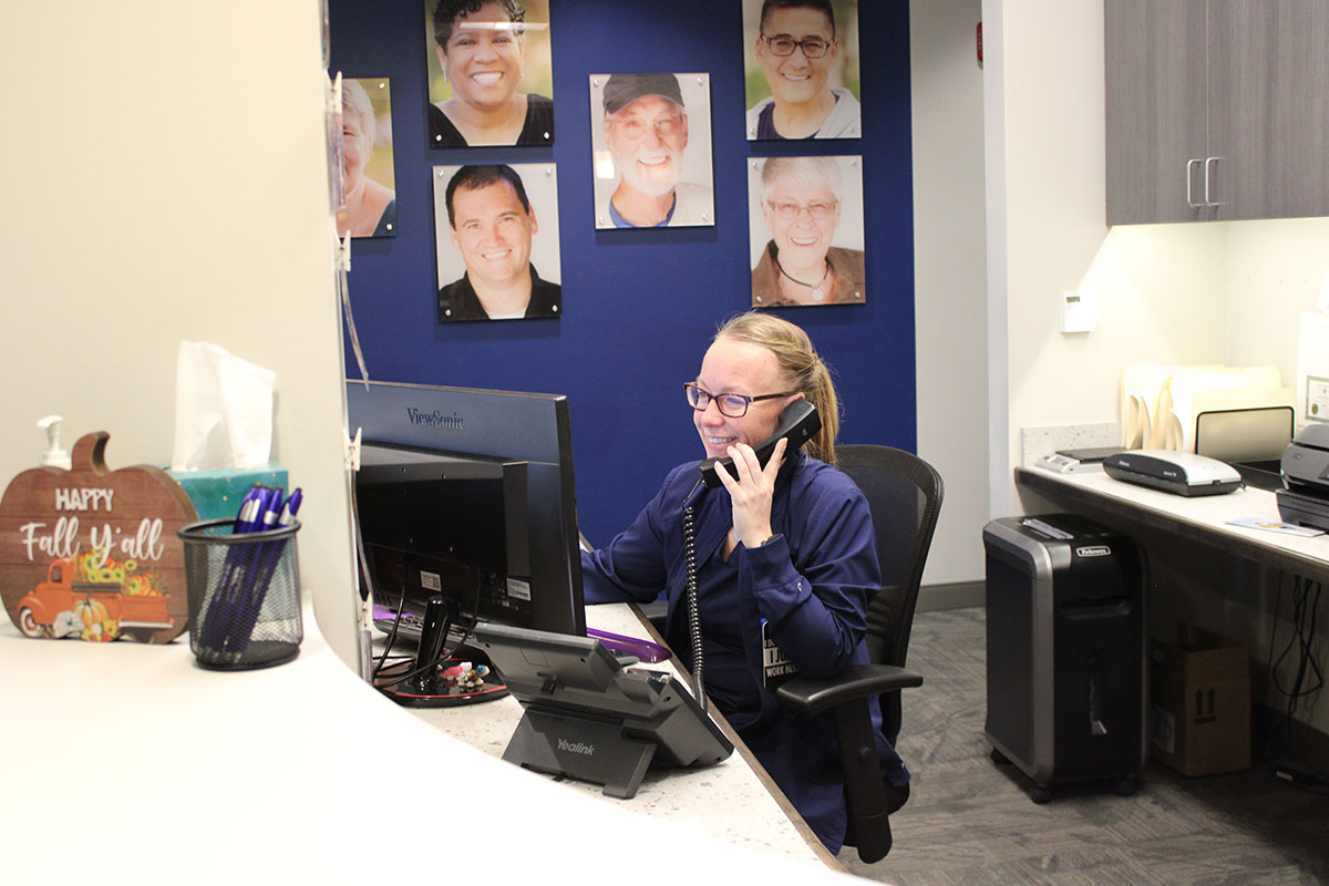 Verifying Insurance Benefits at OP Implant Dental Front desk team member verifying dental insurance benefits by phone at OP Implant Dental in Overland Park